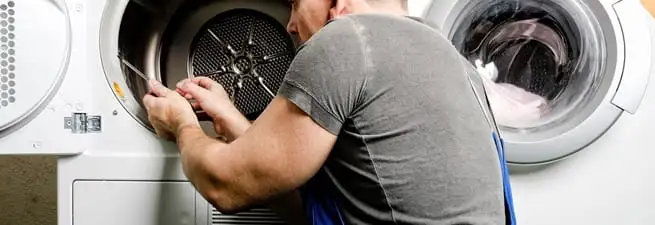 Dryer repair technician fixing a clothes dryer drum in Dayton, OH