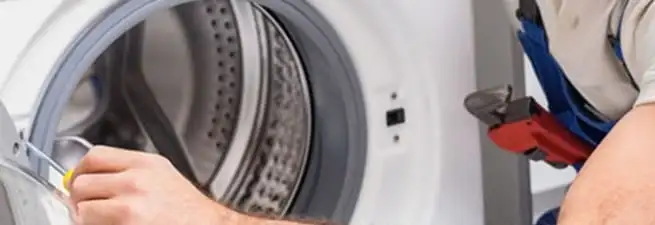 Appliance technician repairing a clothes dryer drum and internal parts in Dayton, OH