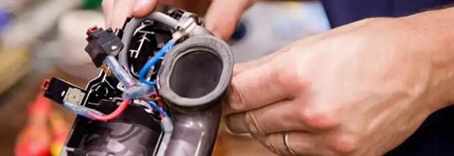 Vacuum repair technician reconnecting wiring and components in Dayton, OH