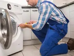 Washing machine repair technician servicing a front-load washer in Dayton, OH